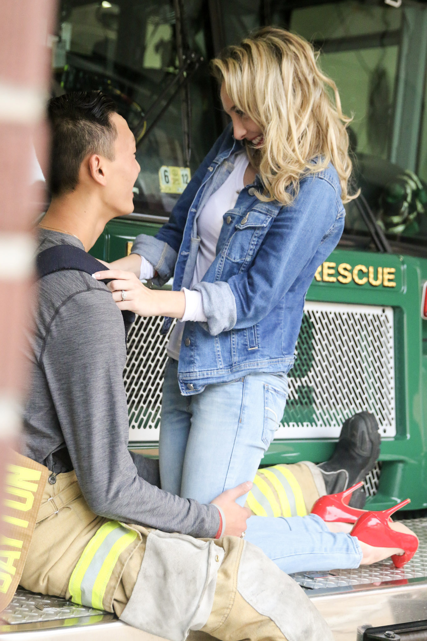 the young lady on her knees in front of the man holding onto his straps.