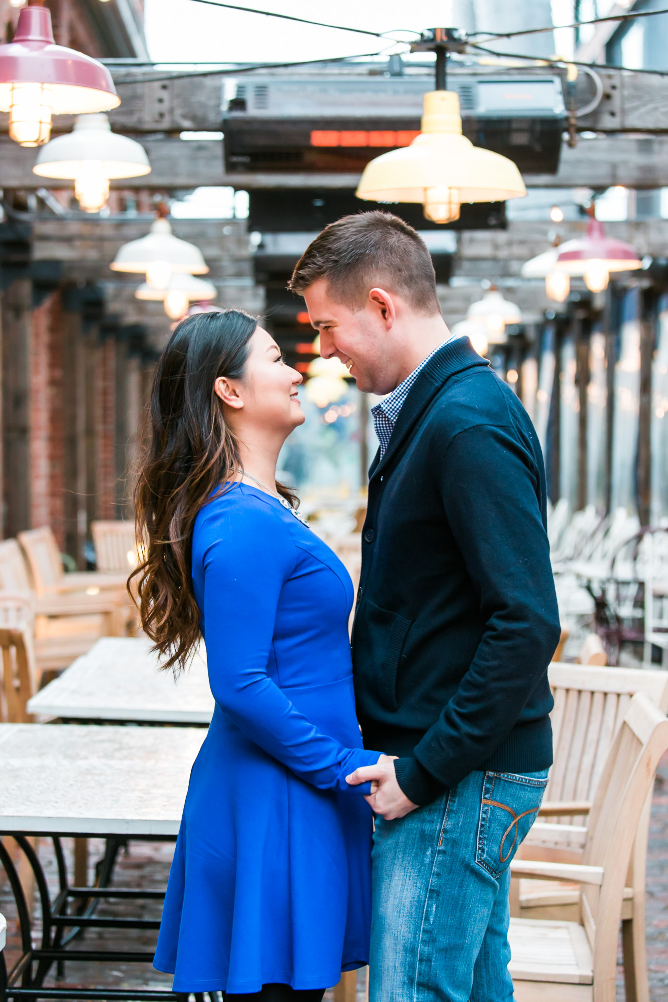 The couple is holding hands and staring at each other affectionately.