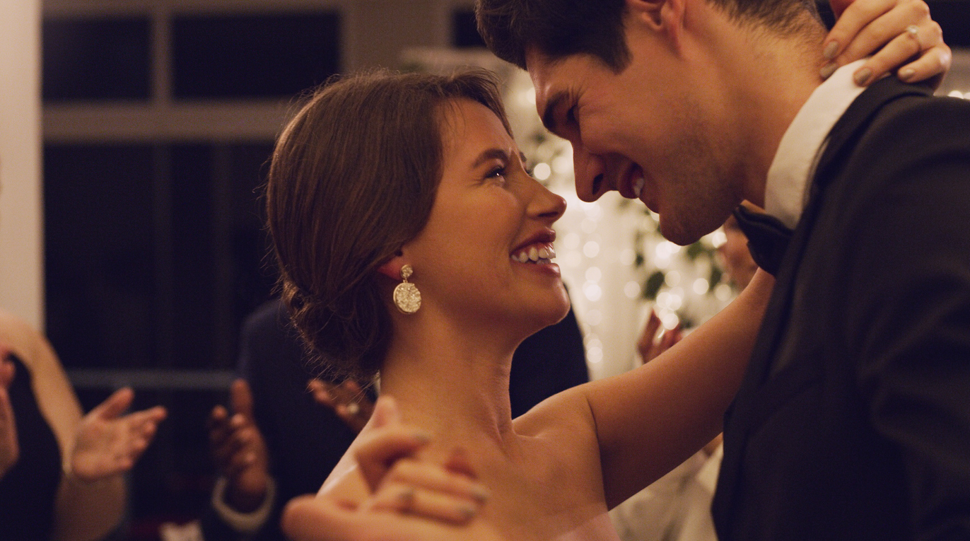 Cropped shot of an affectionate young newlywed couple slow dancing with their guests in the background at their wedding reception