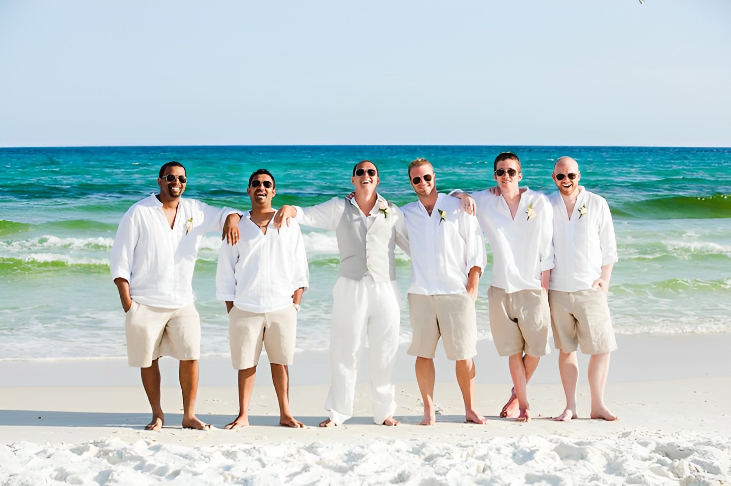 The groom and groomsmen wearing lightweight and breathable clothing for a beach wedding.