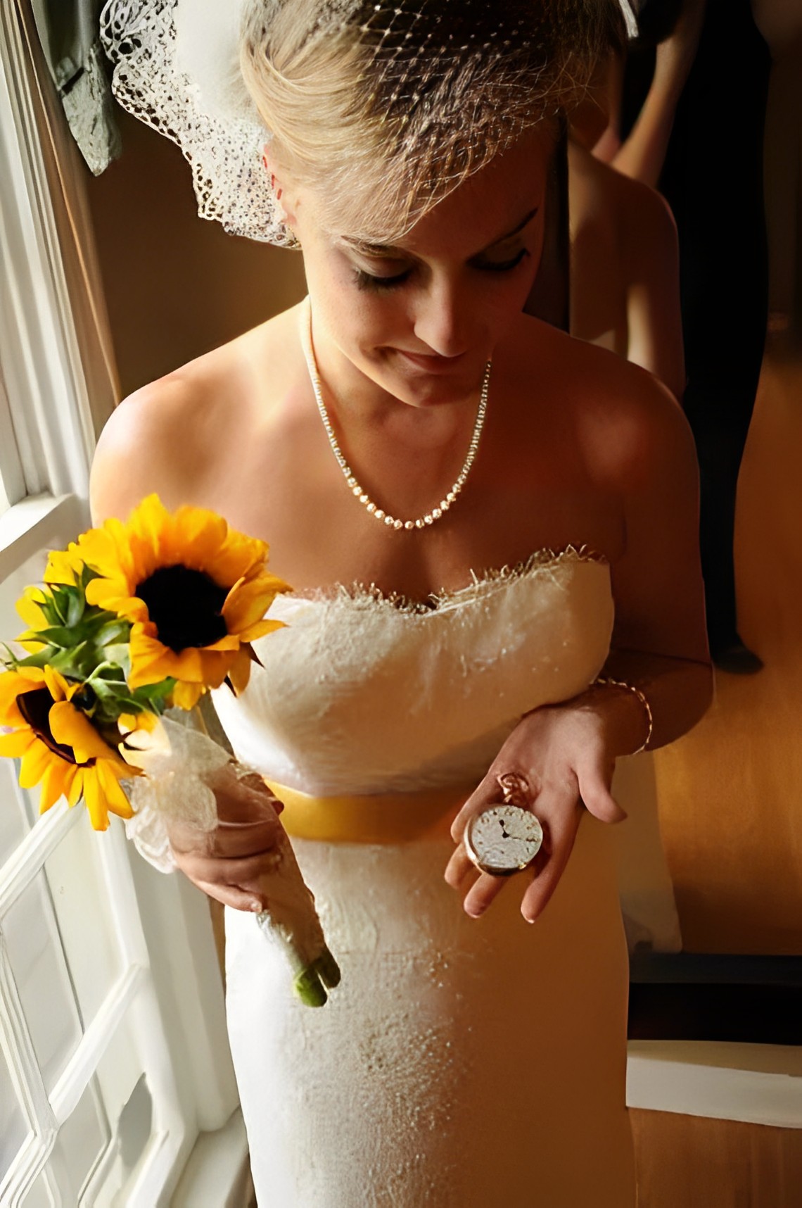 bride carried her father's pocket watch while also holding a sunflower bouquet