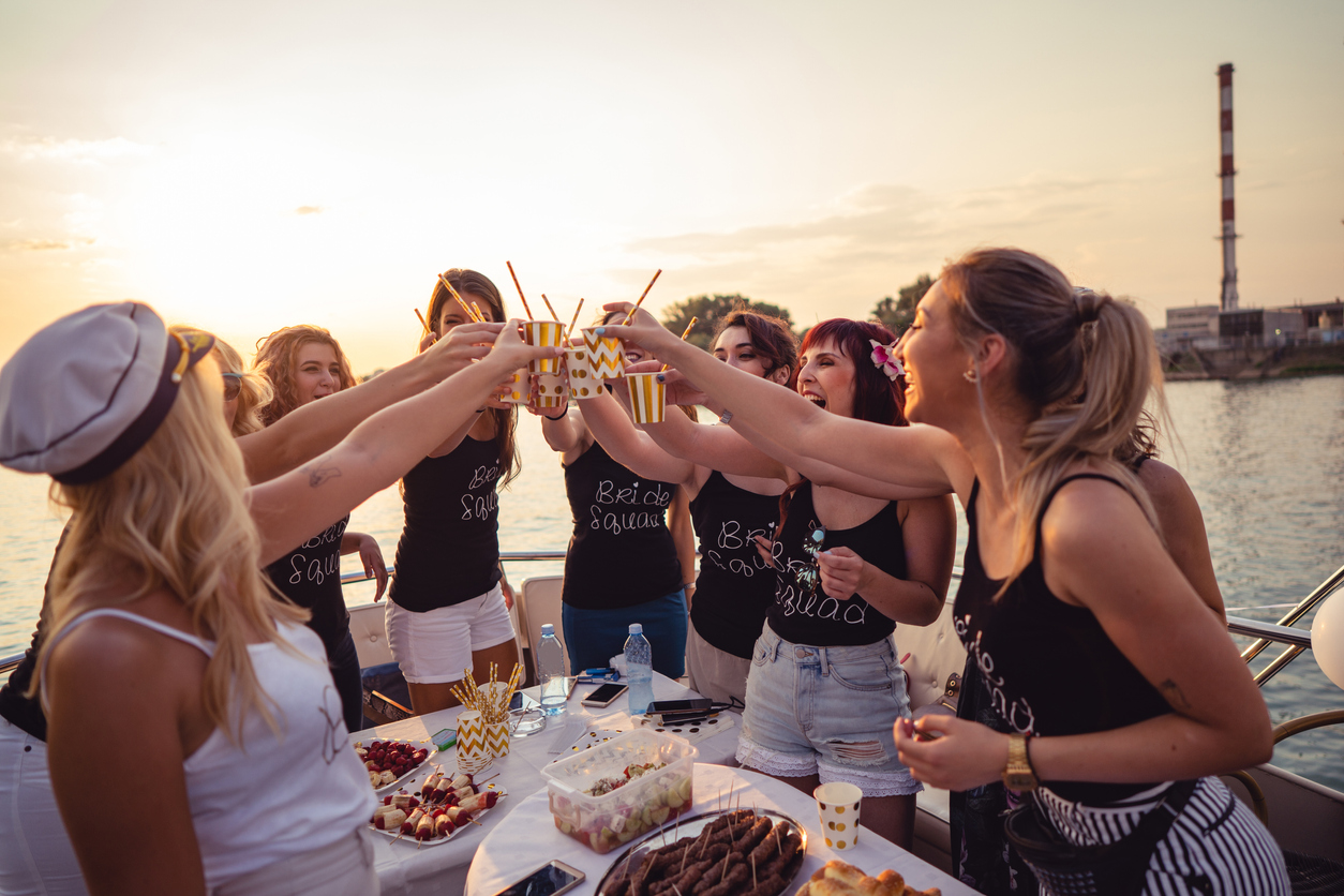 The bride and bridesmaids are having a good time at their bridal shower party on the boat.