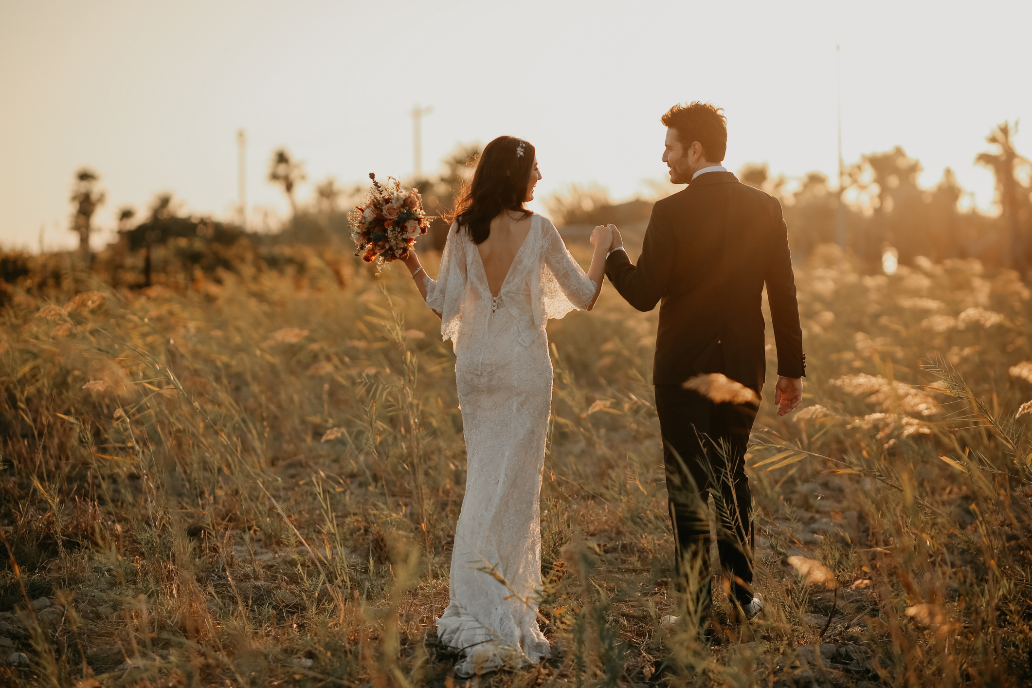 happy bride and groom in a field for wedding photography session