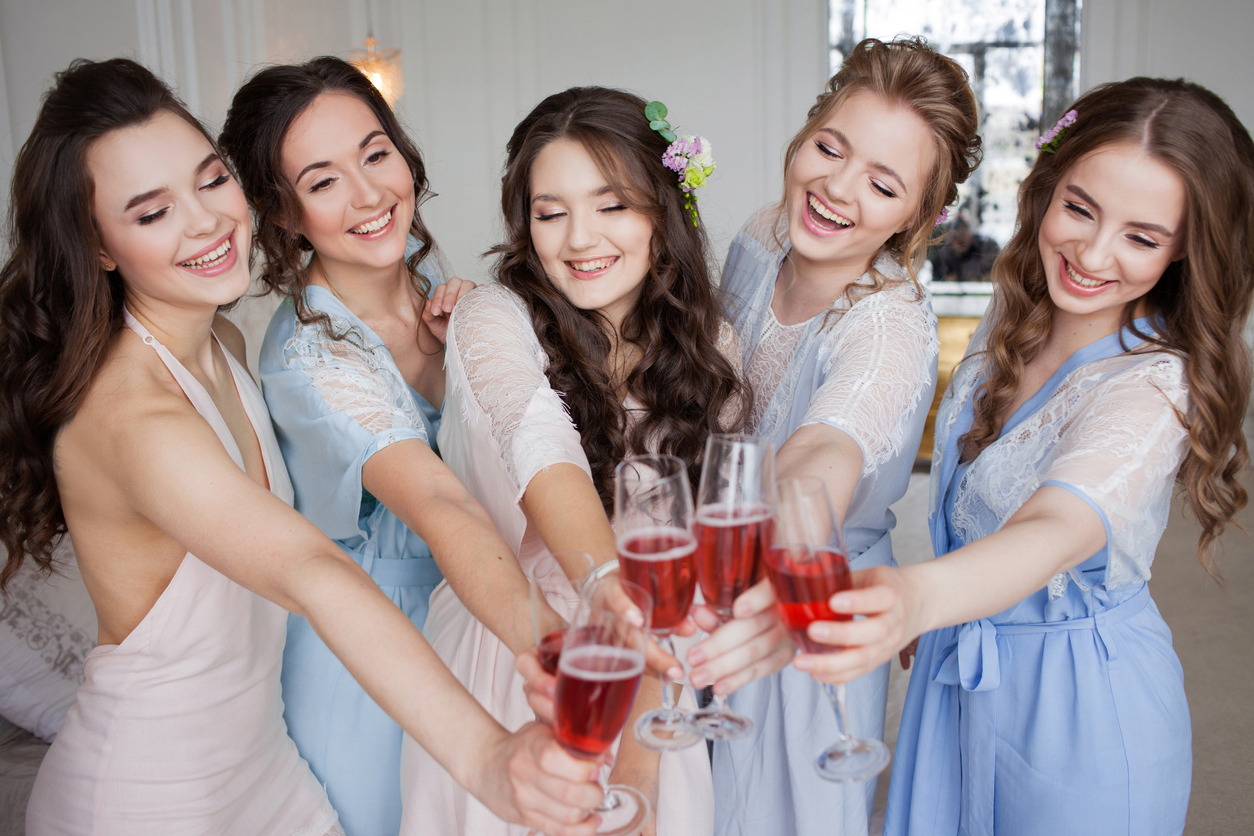 cheerful bride together with bridesmaids having a toast, getting ready for the wedding