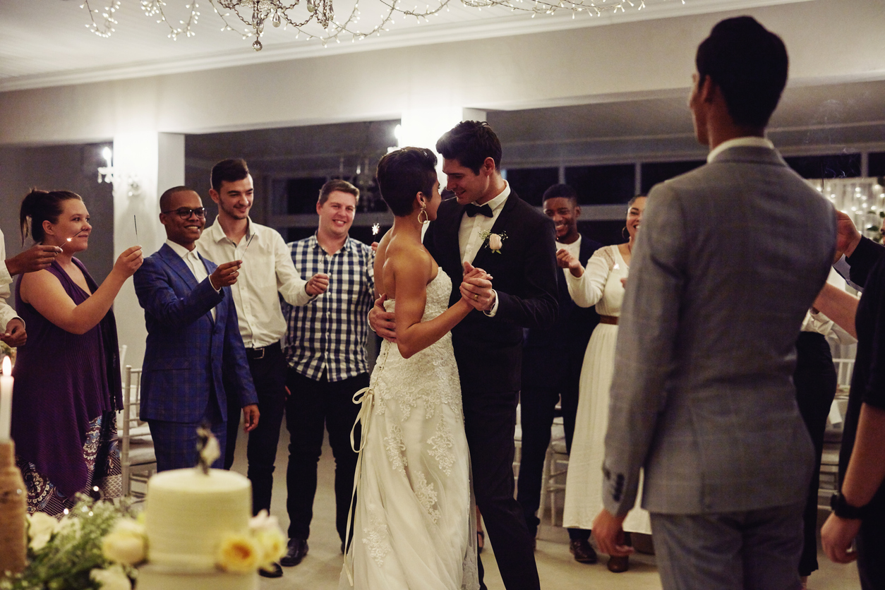 the couple's first dance as husband and wife during their wedding celebration, with people cheering them on.