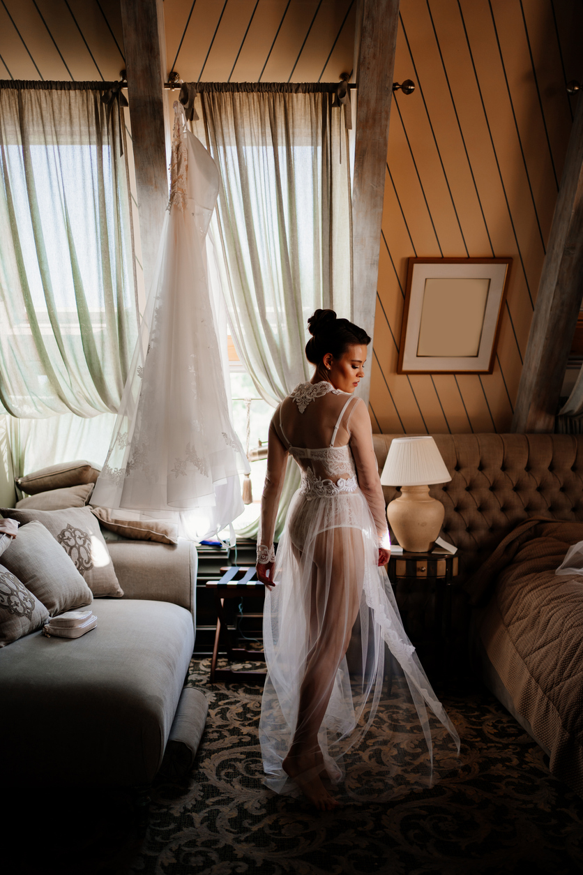 a beautiful bride in a lace robe in a room with a retro interior.