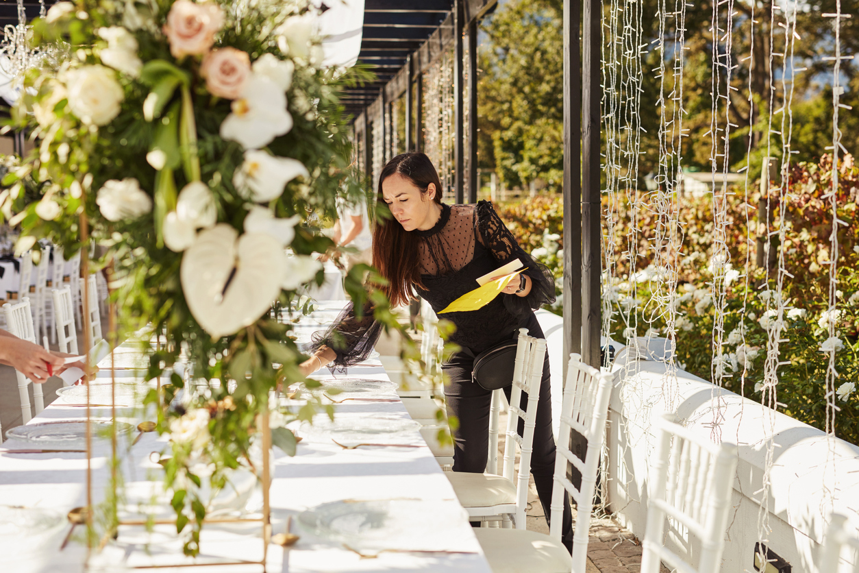 Shot of a young woman decorating a table with place card holders in preparation for a wedding reception