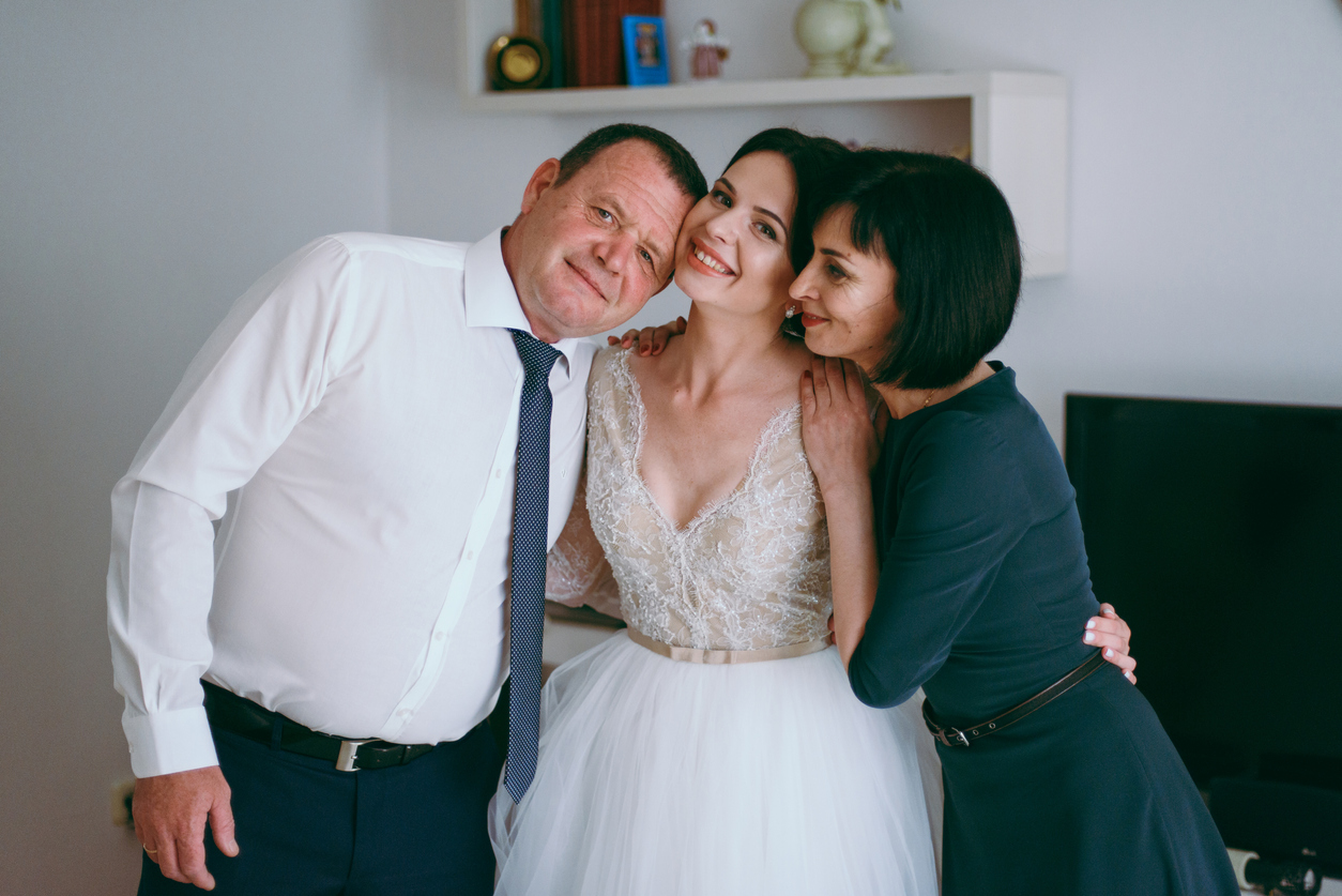 bride hugging both her parents for a photo.