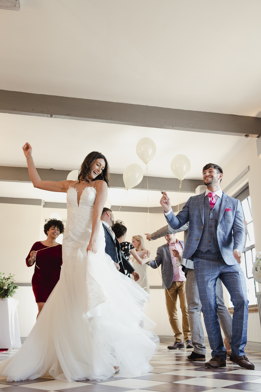 Newly wed couple are enjoying dancing with all of their guests on their wedding day.