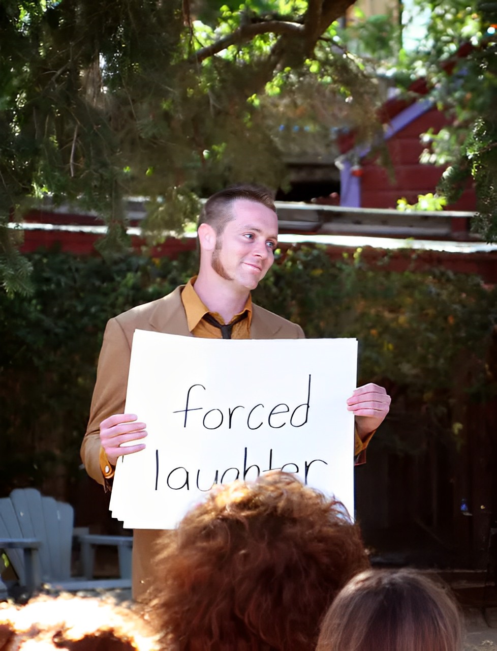 groom holding a cue card, trying not to laugh