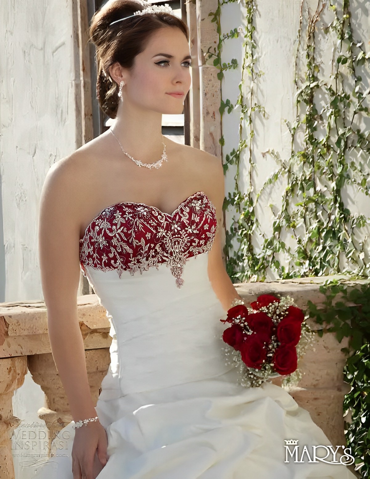 a beautiful bride in unique red and white colored wedding dress accentuated with crystals  holding her round bouquet.