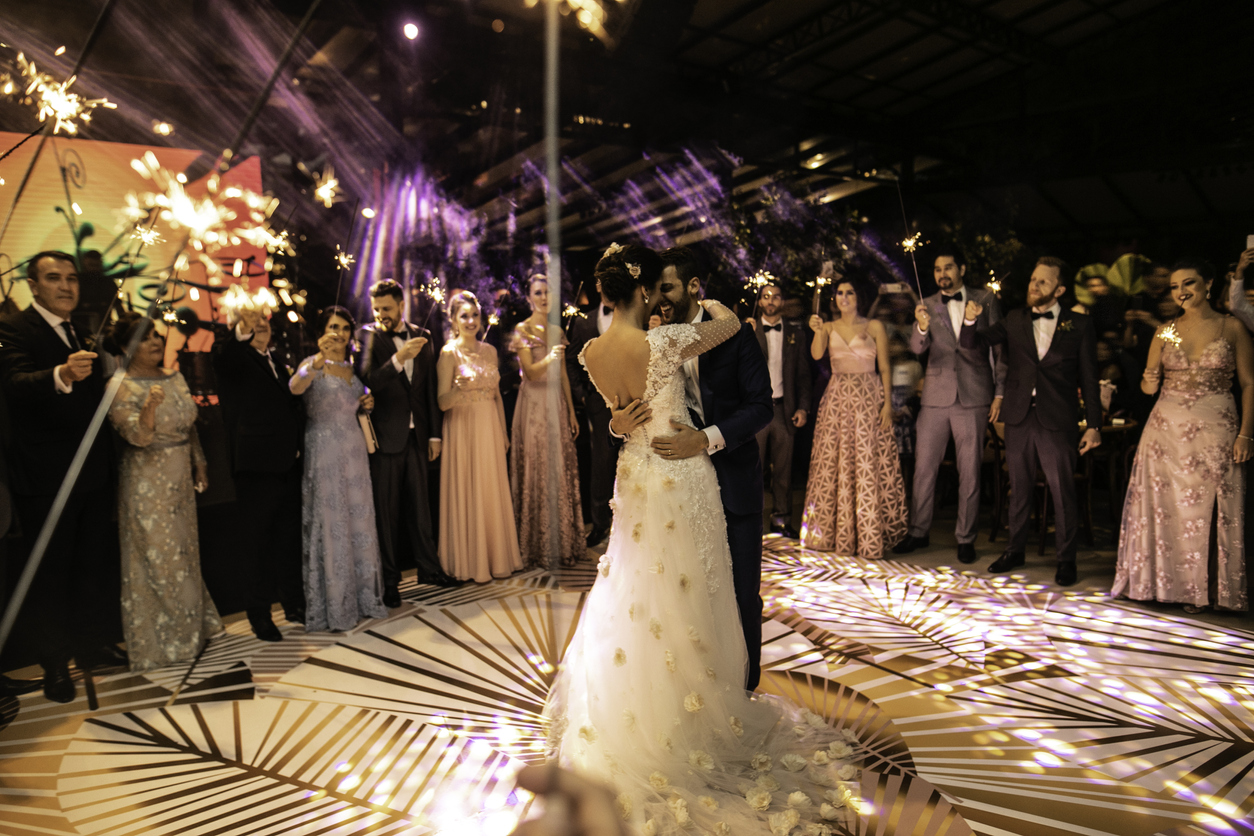 At a wedding reception, the bride and groom performed their first dance with all of their guests surrounding them.