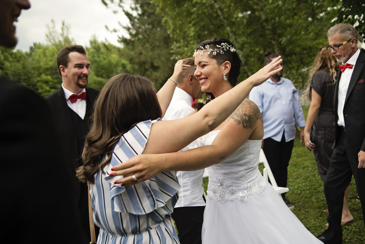 the bride excitedly coming for a hug of a close friend at a wedding.