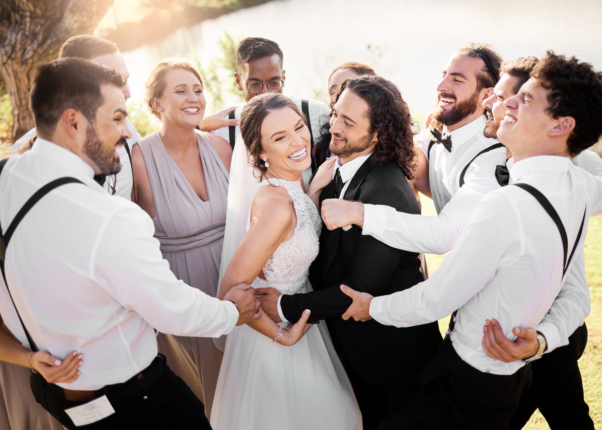 The newlywed couple is surrounded by their bridesmaids and groomsmen, with whom they are pleasantly interacting.