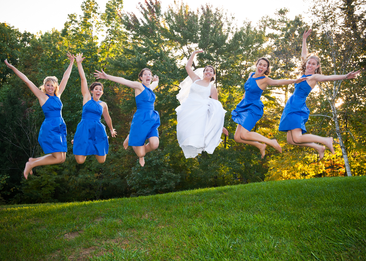 A fun outdoor photograph with the bride and bridesmaids executing jump shots.