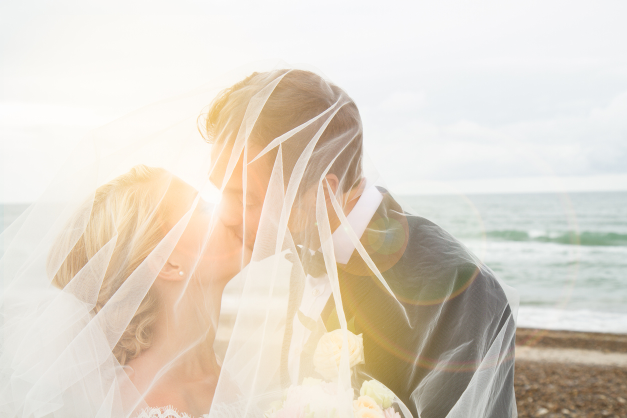 Just married: Wedding picture of young, beautiful couple standing on beach, Denmark