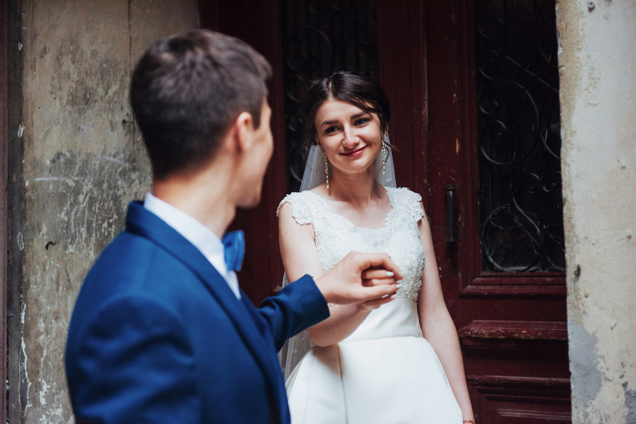 Upon the first sight of her partner, the bride smiles bashfully.