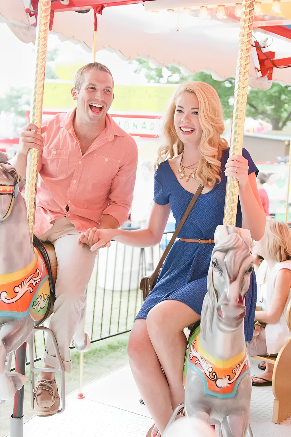 happy couple holding hands while riding a carousel in a carnival