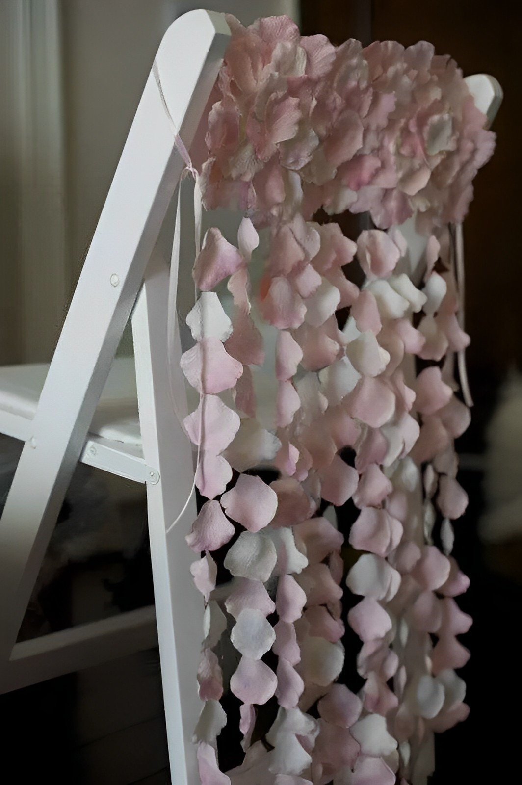 The chair was decorated with light pink and white blossoms.