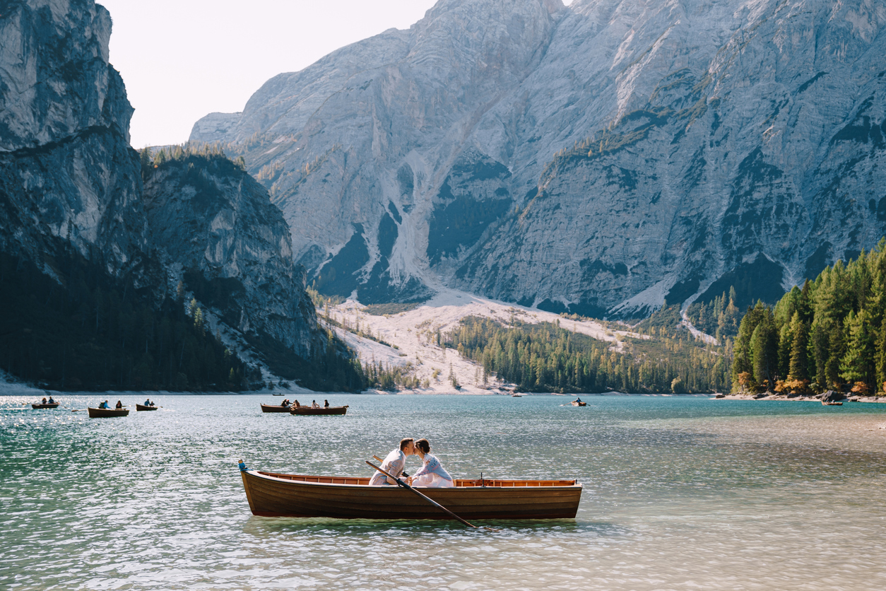 the couple are sitting in the boat and kissing.