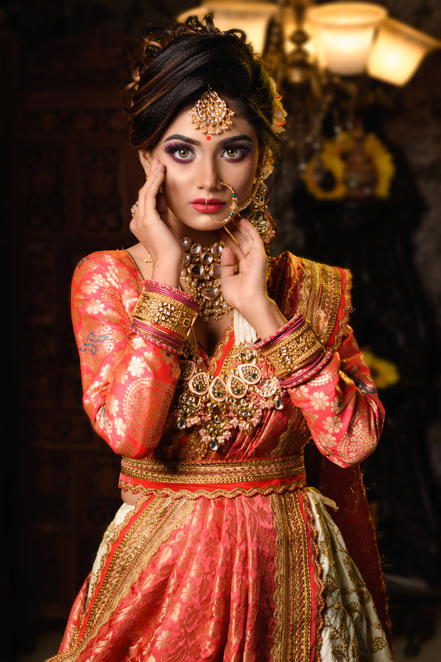 Portrait of very beautiful young Indian bride in luxurious bridal costume with makeup and heavy jewellery in studio lighting indoor. Wedding fashion.