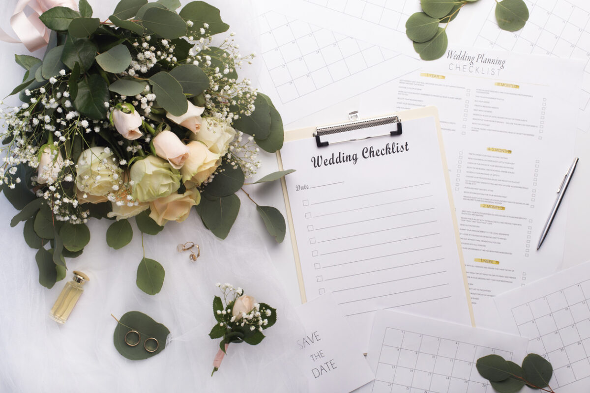 wedding checklist on the table with a bouquet of roses.