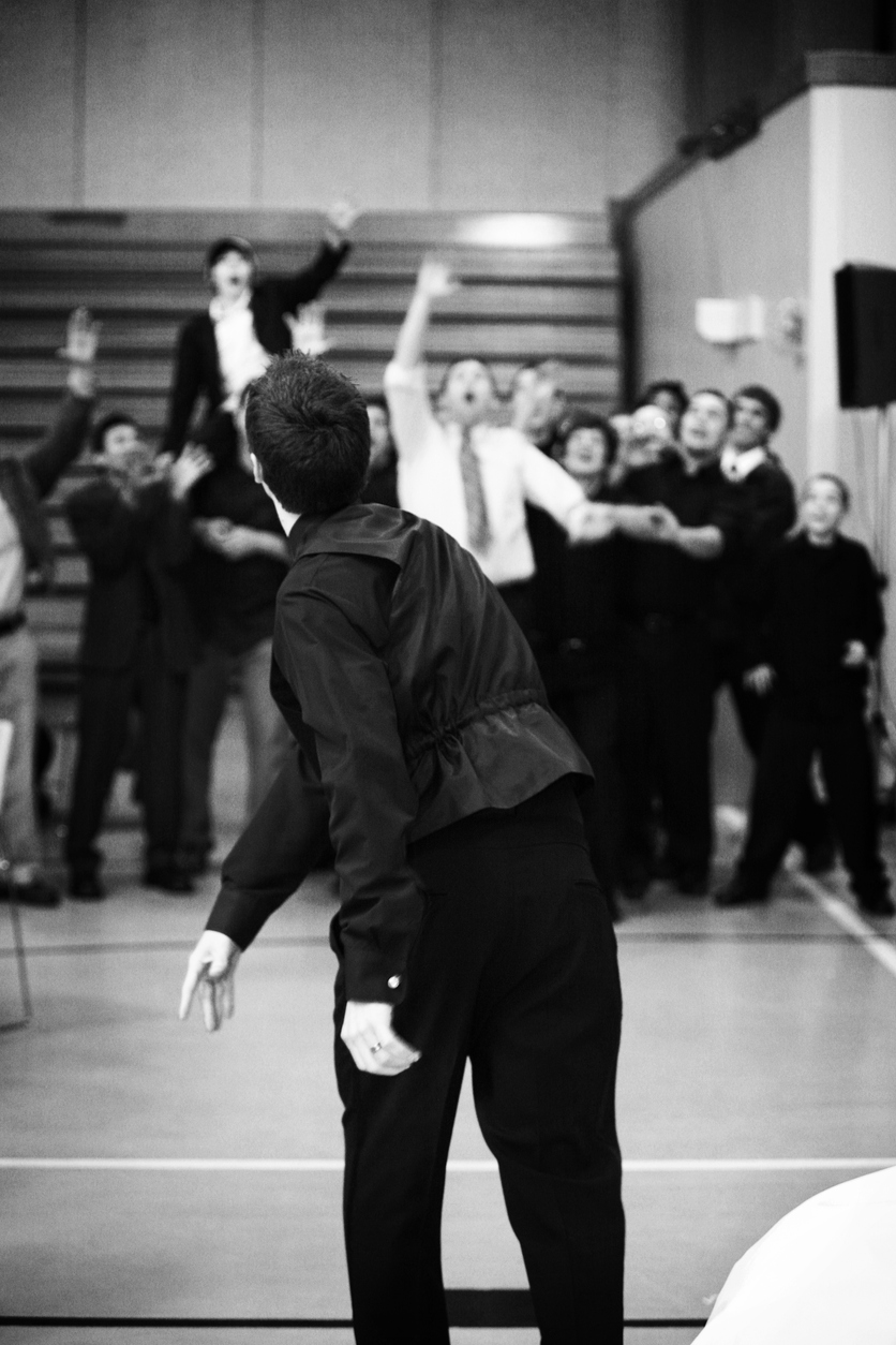 the groom toss the garter to the excited groomsmen at the back.
