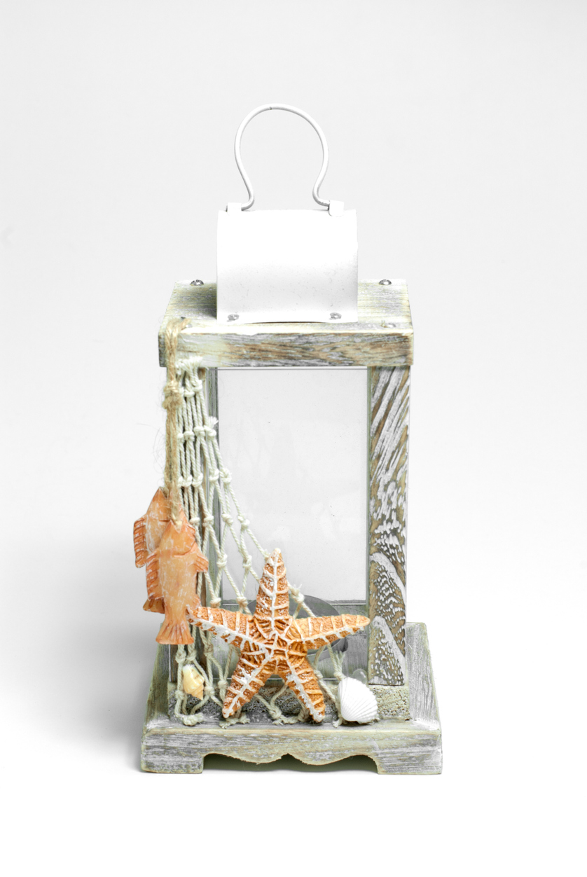 a wooden white beach-themed lantern with a net and an orange-colored starfish, fishes and some seashells added extra cuteness.