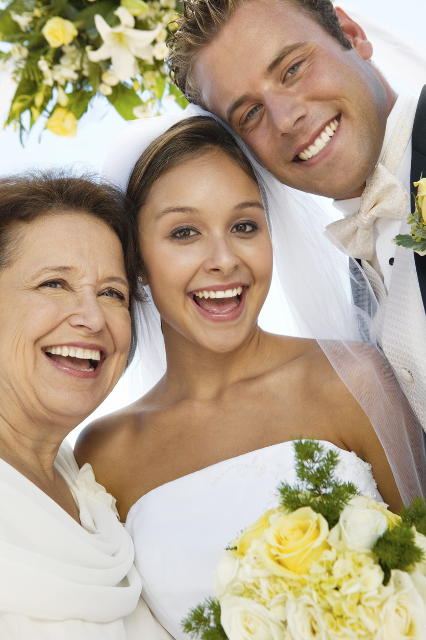 The mother of the bride, the groom, and the bride herself are all smiling in this gorgeous shot.