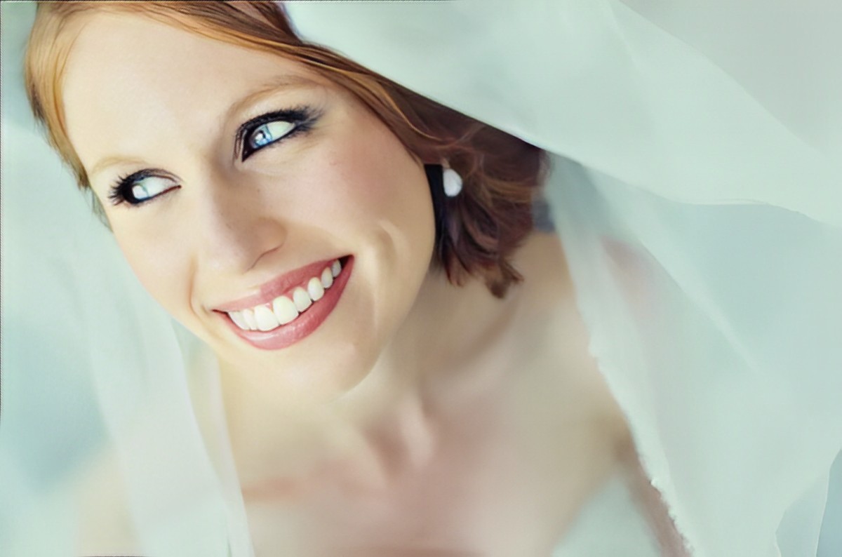 glowing bride beaming with a smile in this  lovely photo with her veil.