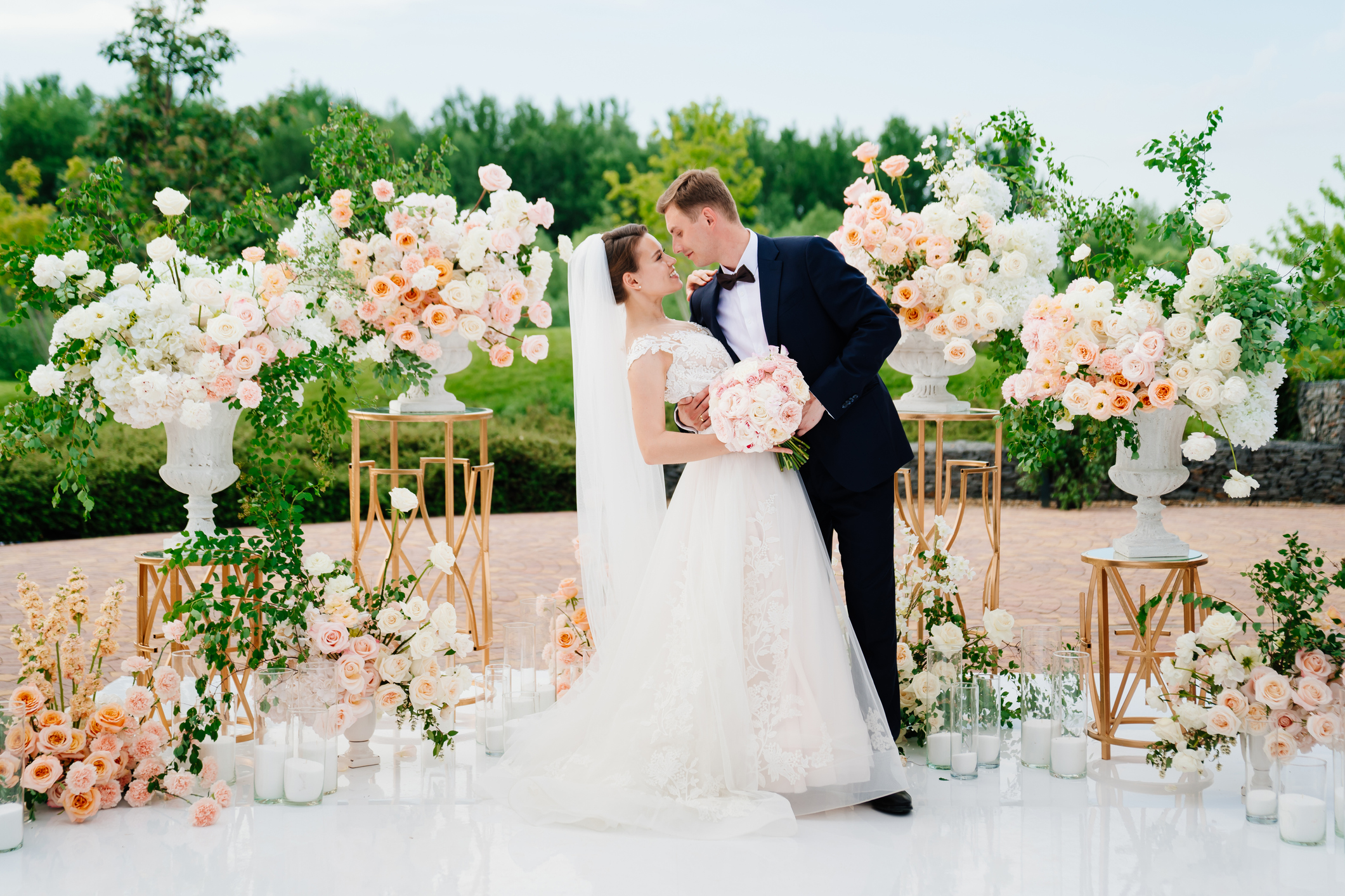 bride and groom in the wedding ceremony area of live white and pink flowers