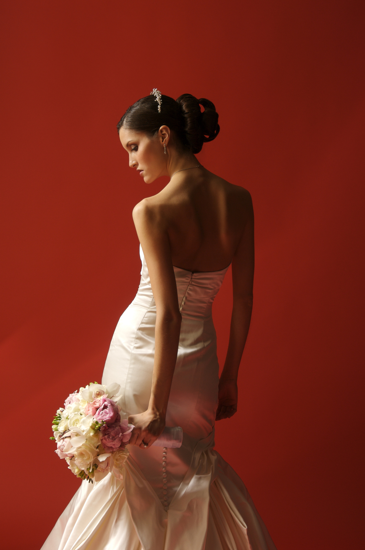 Beautiful bride with bouquet on red background