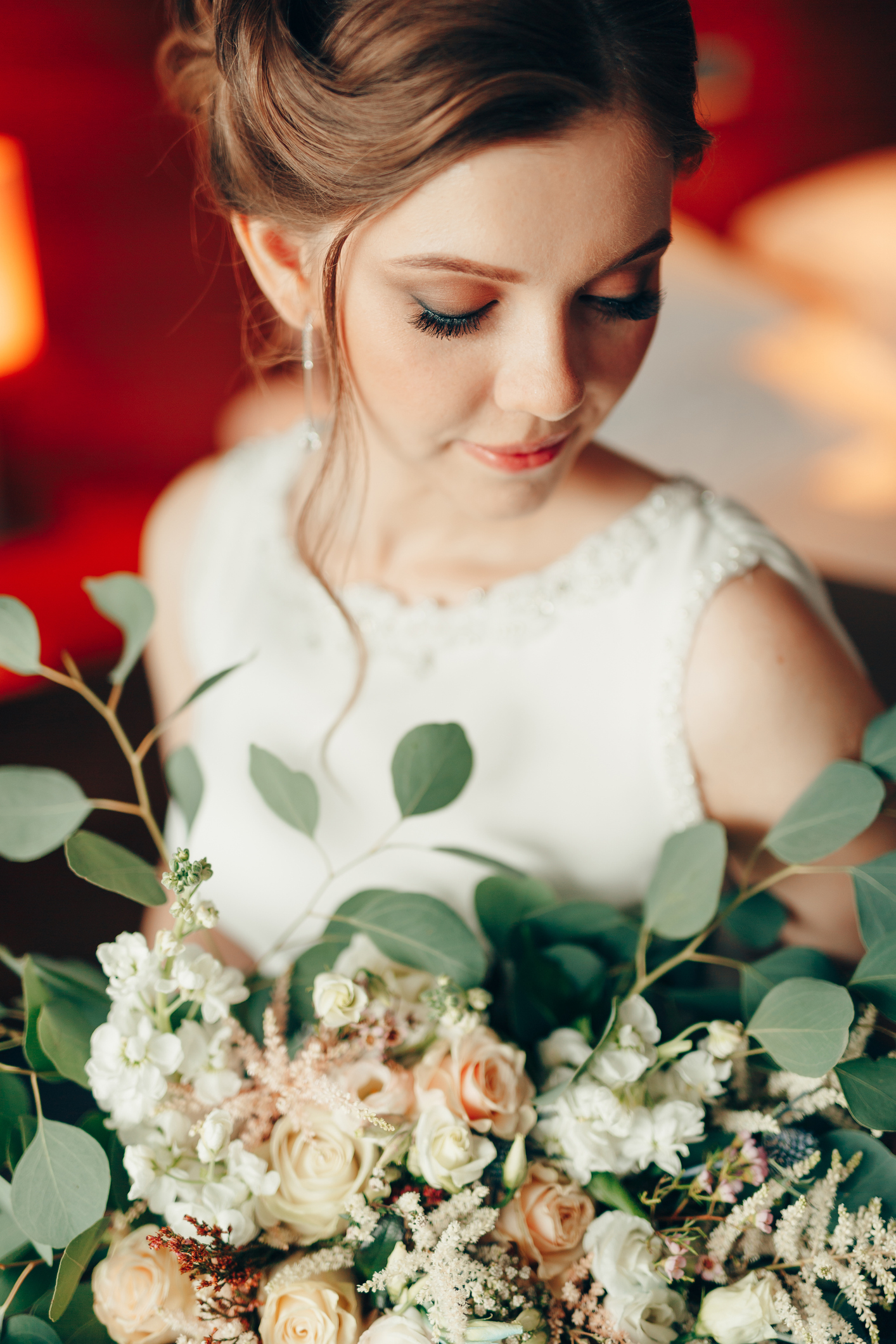 Beautiful bride in a white lace dress with a bouquet of flowers in the room. Portrait. High quality photo