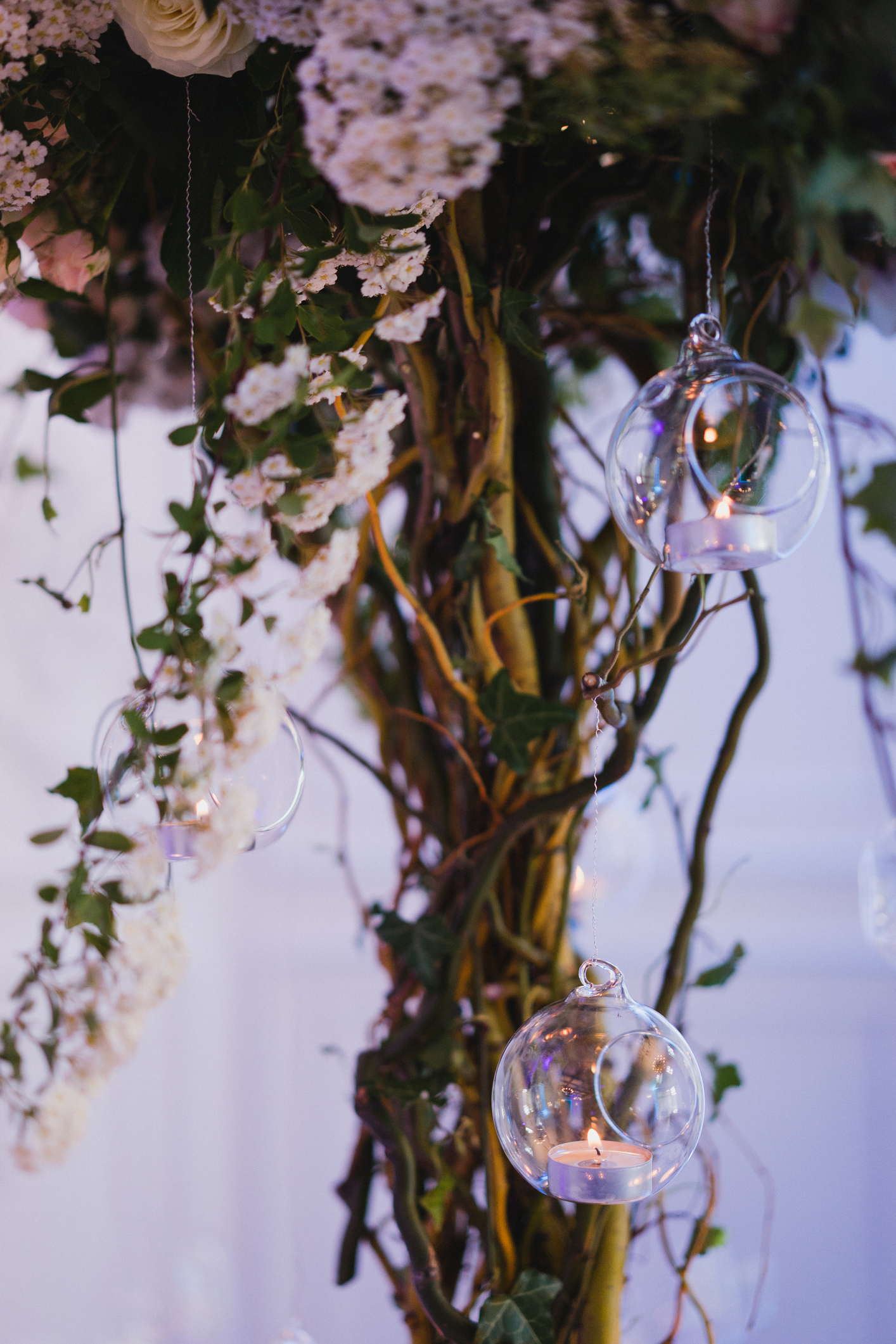 Table setting at the wedding reception. Floral compositions with beautiful flowers and greenery, candles, laying and plates on a decorated table.