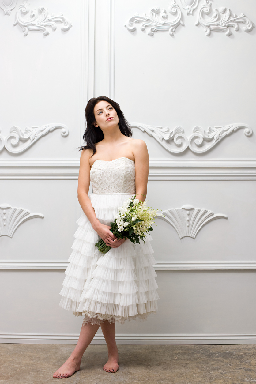 bride in her white tea-length wedding dress with a bouquet in her hands.