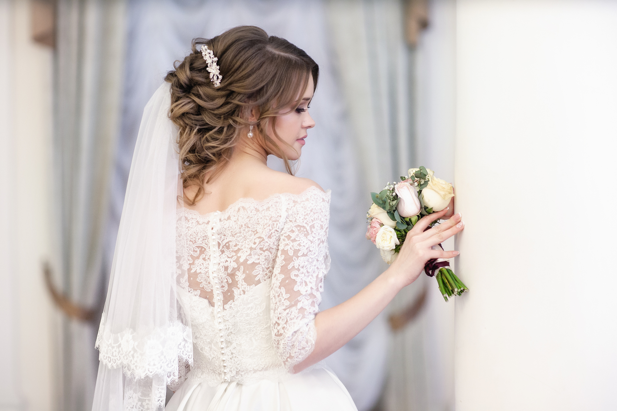 portrait of the bride against the window. Vertical shot. The middle plan.