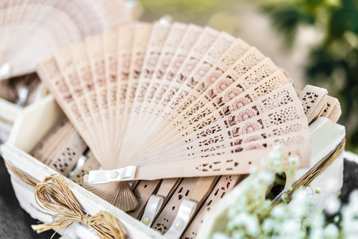 A beige hand fan can keep your guests cool at a summer wedding.