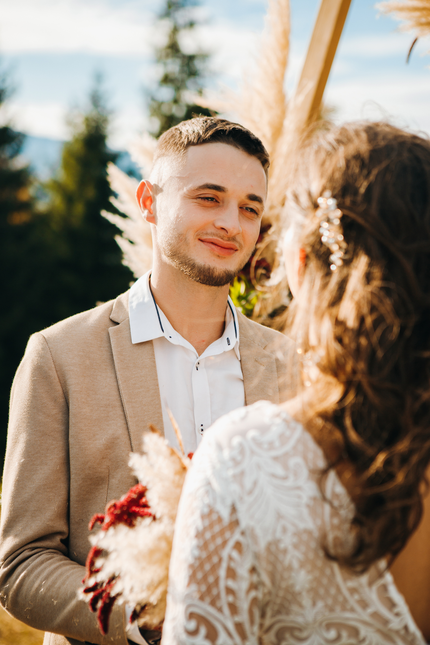 Happy groom standing in front of his wife. Fall wedding session.