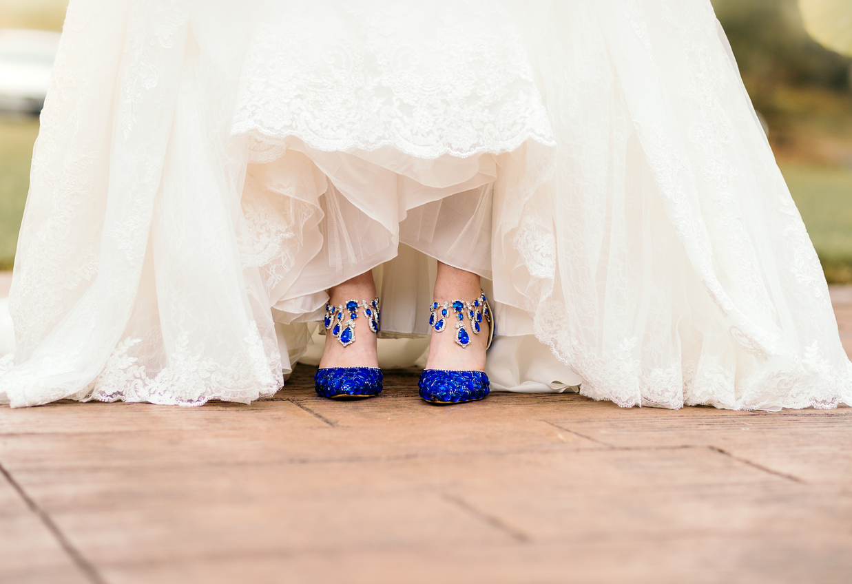 A stunning bride's sapphire studded shoes pop from underneath her whimsical white dress.