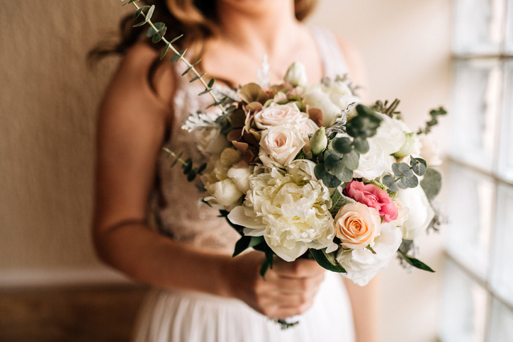 Rustic bridal bouquet of roses, peonies, and eucalyptus leaves.